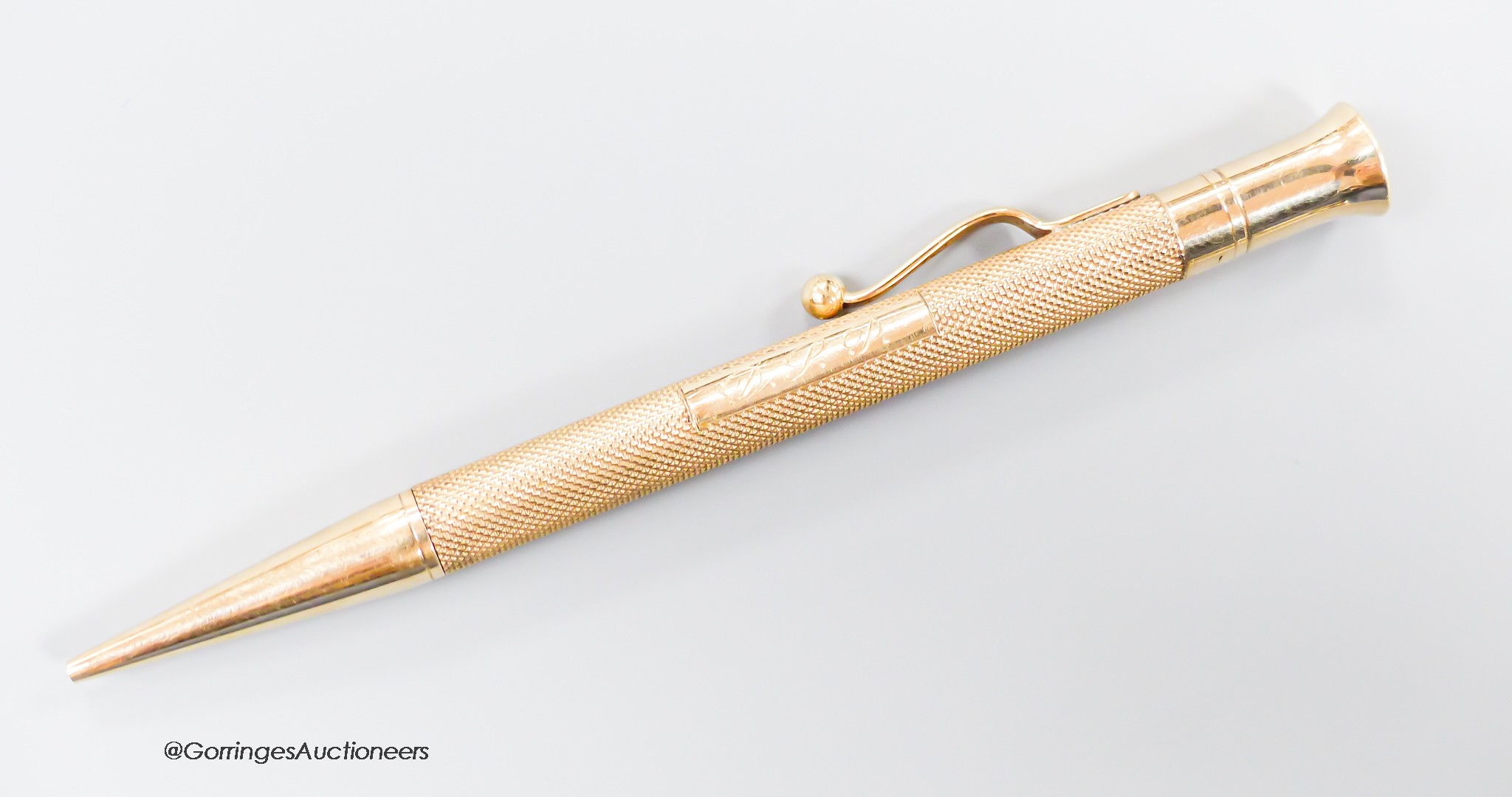 A late 1940's engine turned 9ct gold cased pencil, with engraved initials, 12.1cm.